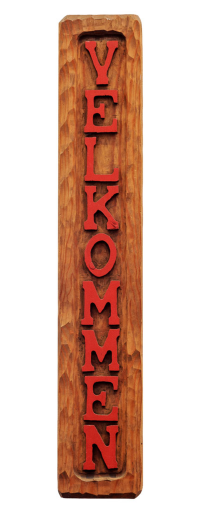 Carved wooden sign with red lettering, saying velkommen